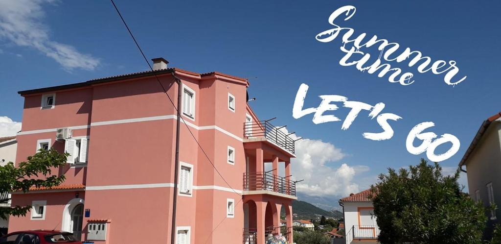 a pink building with the words summer time lets go at Apartments Aleksandra in Rab