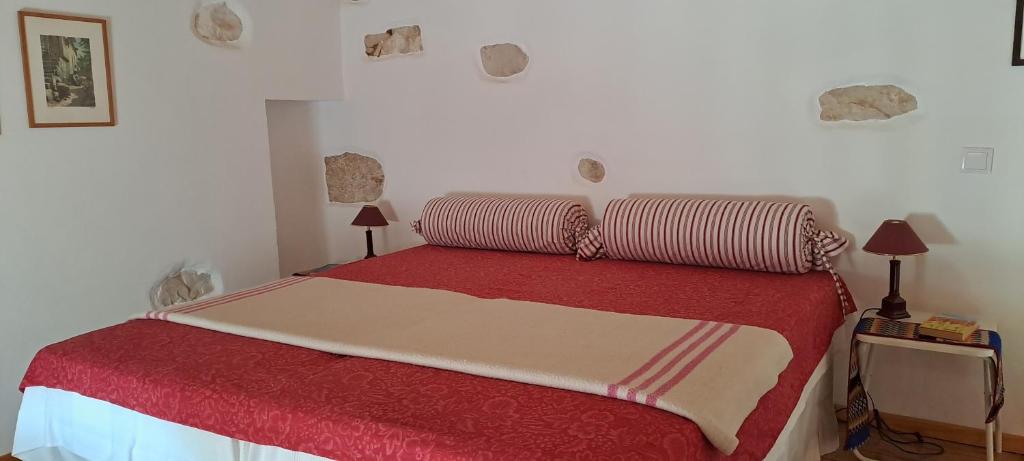 a bedroom with a red bed with two pillows at Parreirais dos Moquinhos in Minde