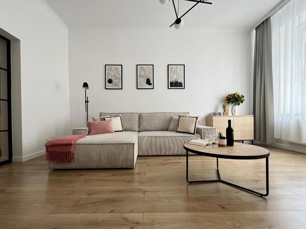 ein Wohnzimmer mit einem Sofa und einem Tisch in der Unterkunft Apartamenty Wolwowicz in Jelenia Góra