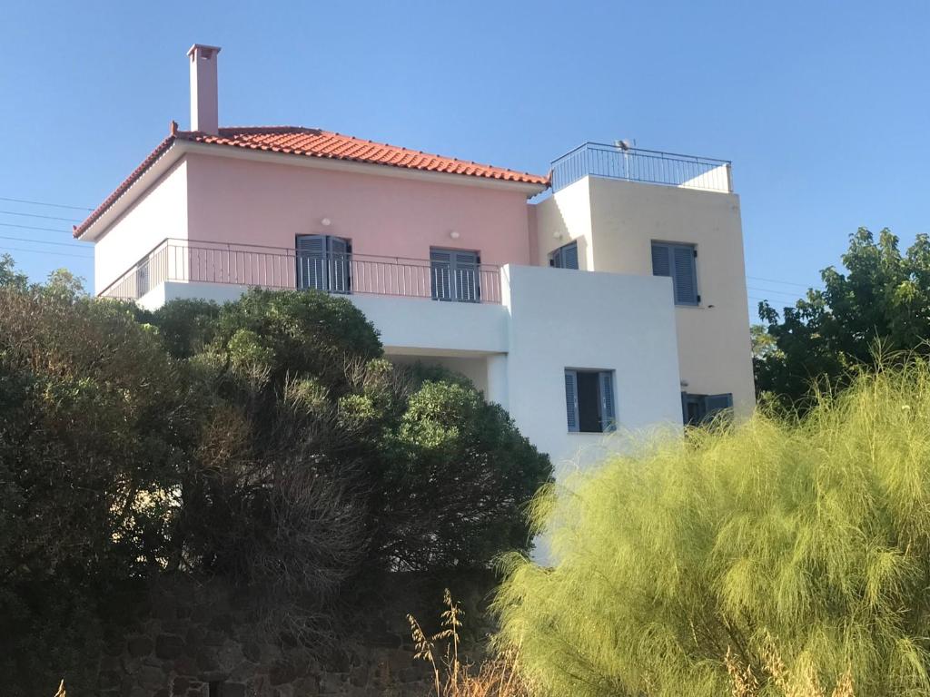 a white house on top of a hill with trees at Aegina Vagia Sea Breeze Vacation Villa in Vaia