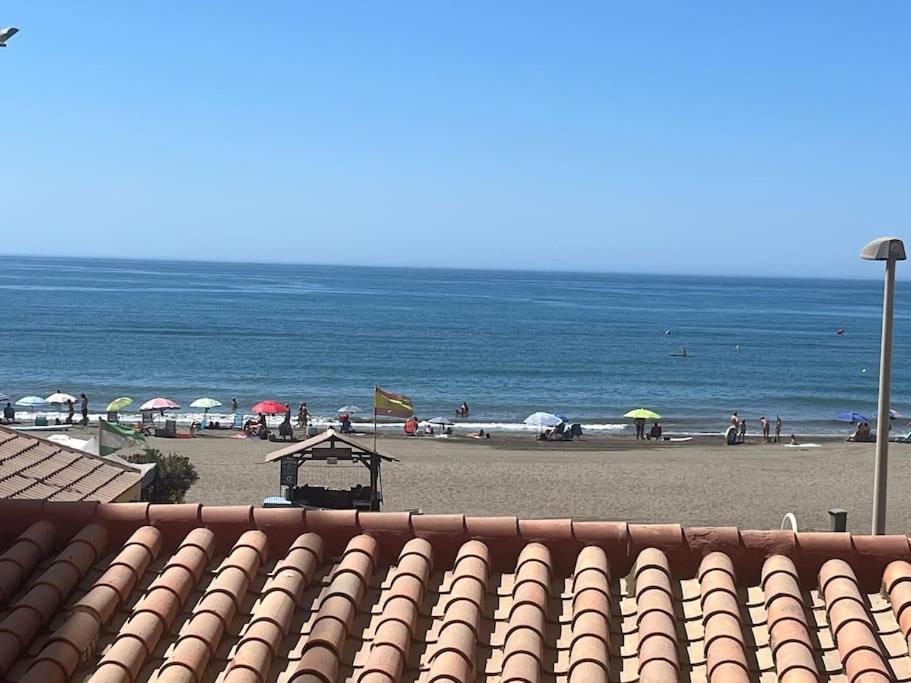 - une plage avec des parasols et des personnes sur la plage dans l'établissement primera linea playa rincon de la victoria, à Rincón de la Victoria