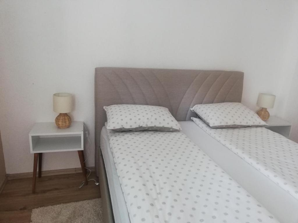 una camera con 2 letti singoli e un comodino di Apartman Radanović a Foča