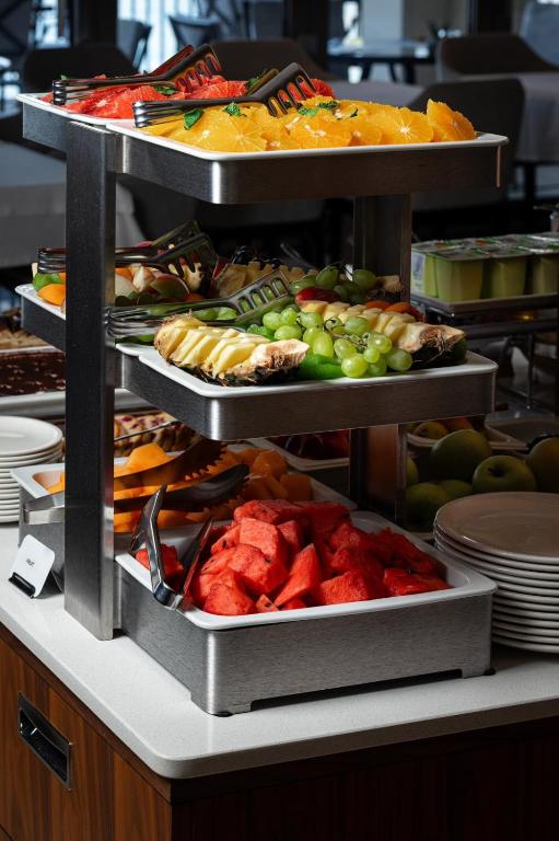 a buffet with several trays of different types of food at Hotel California by Aycon in Sveti Stefan