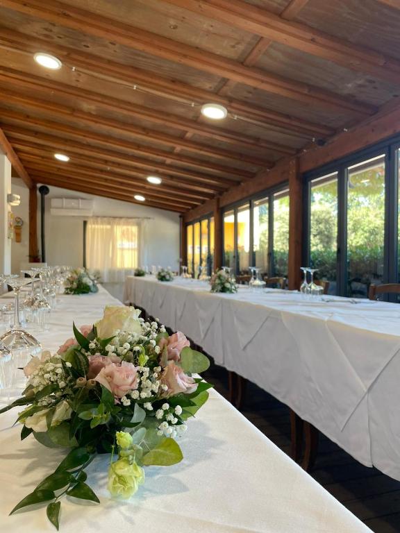 rzędu stołów w pokoju z kwiatami w obiekcie Hotel Ristorante Le Querciolaie dei Ricci w mieście Fonteblanda