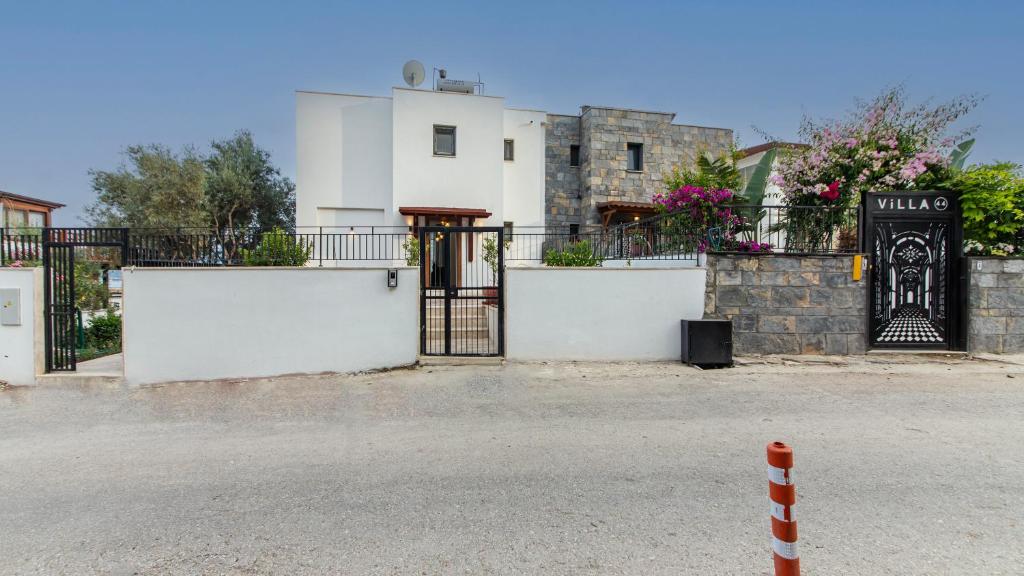 a white building with a gate in front of a street at Villa House Apart Türkbükü in Bodrum City