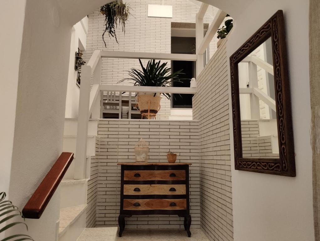 a stairway with a mirror and a wooden dresser at La casa de loto in Alcalá de los Gazules