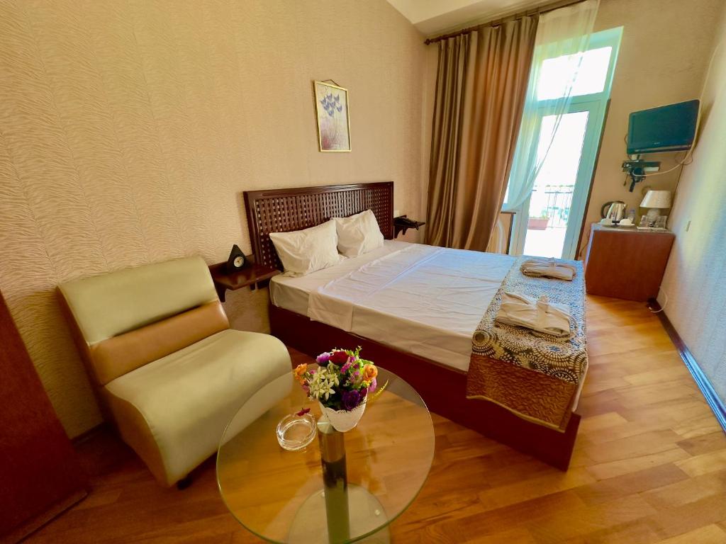 a hotel room with a bed and a table and a chair at Nur Hotel Sea View in Baku