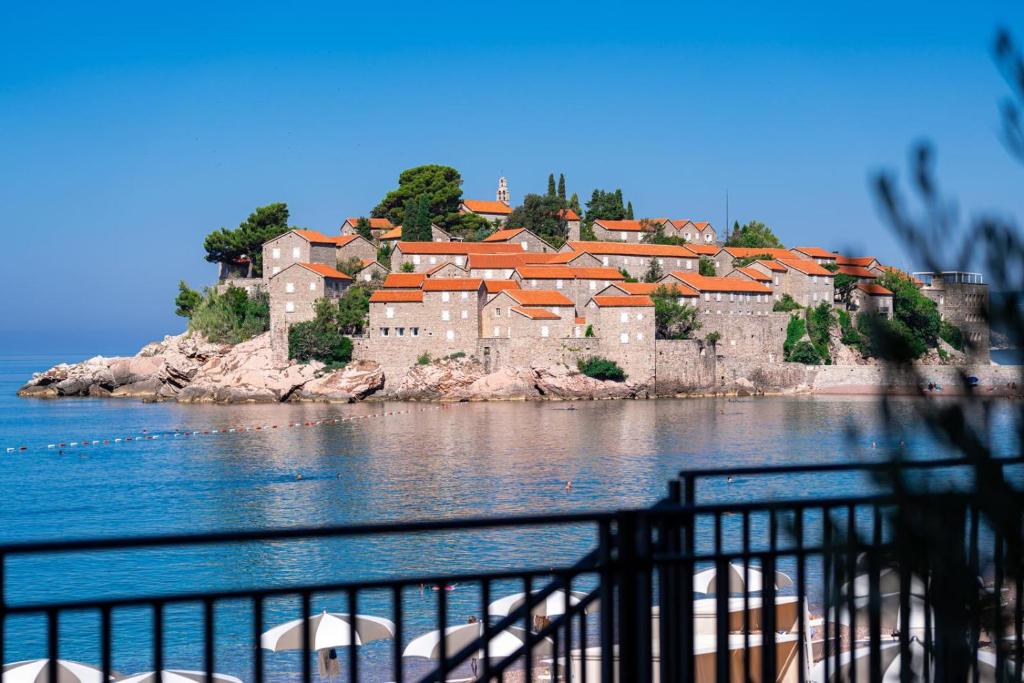 a large castle on the shore of a body of water at Hotel California by Aycon in Sveti Stefan