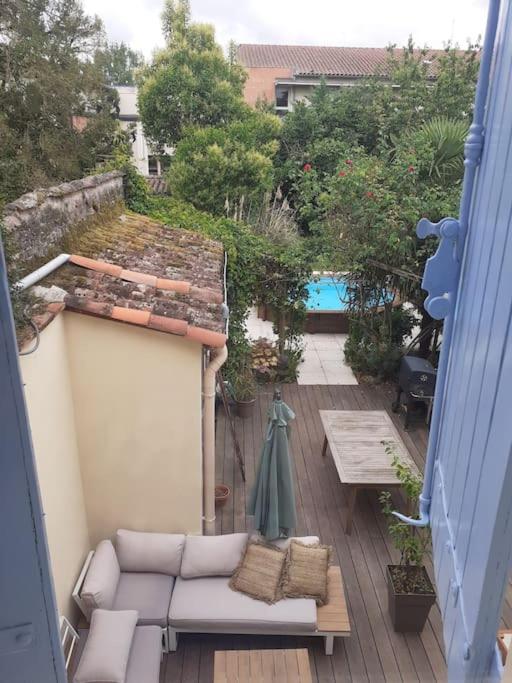 a view of a patio with a couch and a table at Albi centre ville -piscine view our profile please in Albi