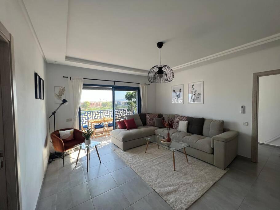 een woonkamer met een bank en een tafel bij Luxus-Unterkunft mit Bergblick! in Martil
