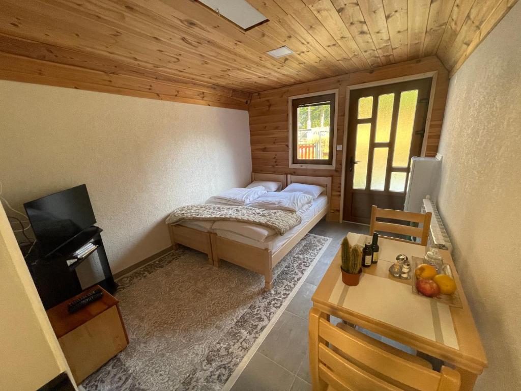 a small bedroom with a bed and a television at Small house Floki in Žabljak