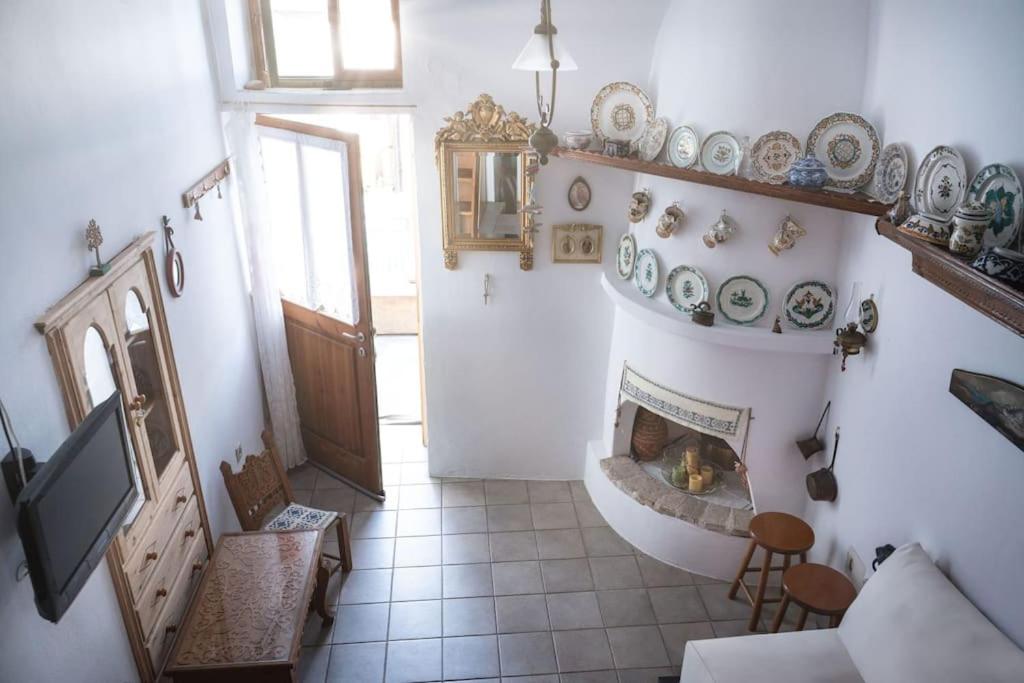 a living room with a fireplace in a house at Το παραδοσιακό σπίτι του Φτούλη! in Skiros