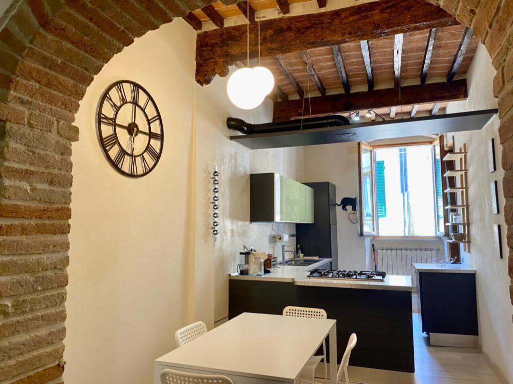 a kitchen with a table and a clock on the wall at A casa di Rita in Città di Castello