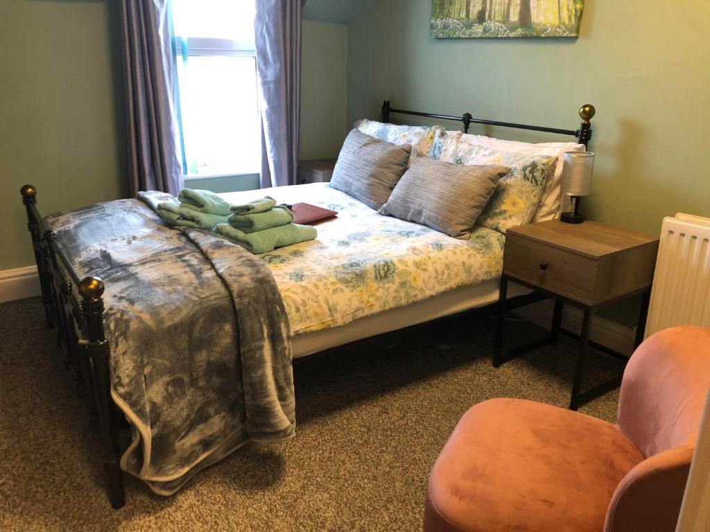 a bedroom with a bed and a chair at New Bond Hotel in Blackpool