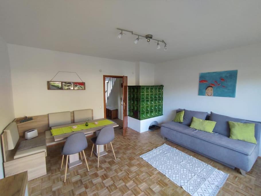 un soggiorno con divano blu e tavolo di Appartement am See in Velden a Velden am Wörthersee