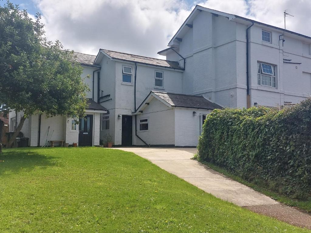 a large white house with a grass yard at Spacious, modern first floor flat near beach and ferry in East Cowes