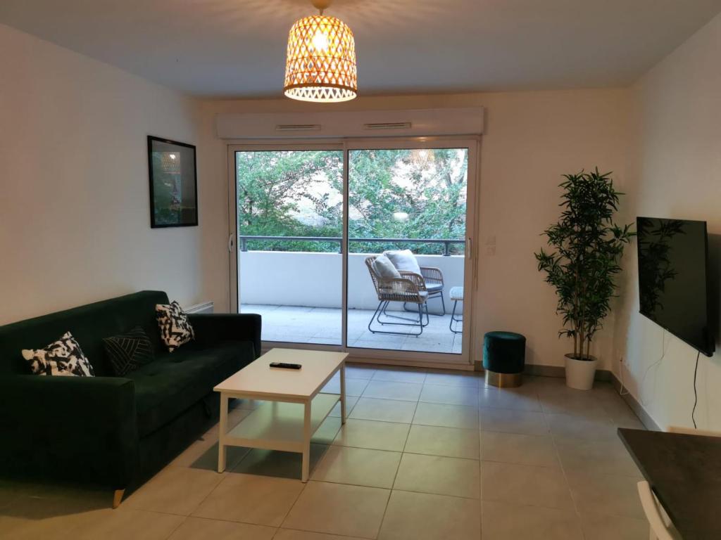 een woonkamer met een bank en een tafel bij Magnifique appartement pour 8 personnes à Montpellier - WIFI/PARKING in Montpellier