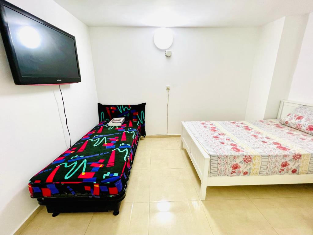 a room with two beds and a flat screen tv at ТИХАЯ КВАРТИРА ДЛЯ ОТДЫХА! in Haifa