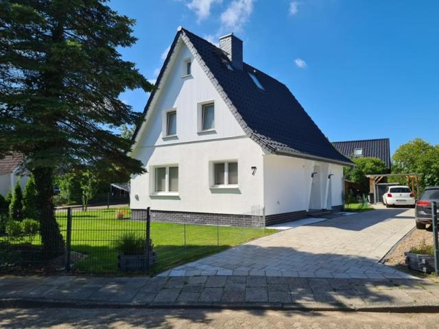 a large white house with a black roof at Ferienhaus Damian in Cuxhaven