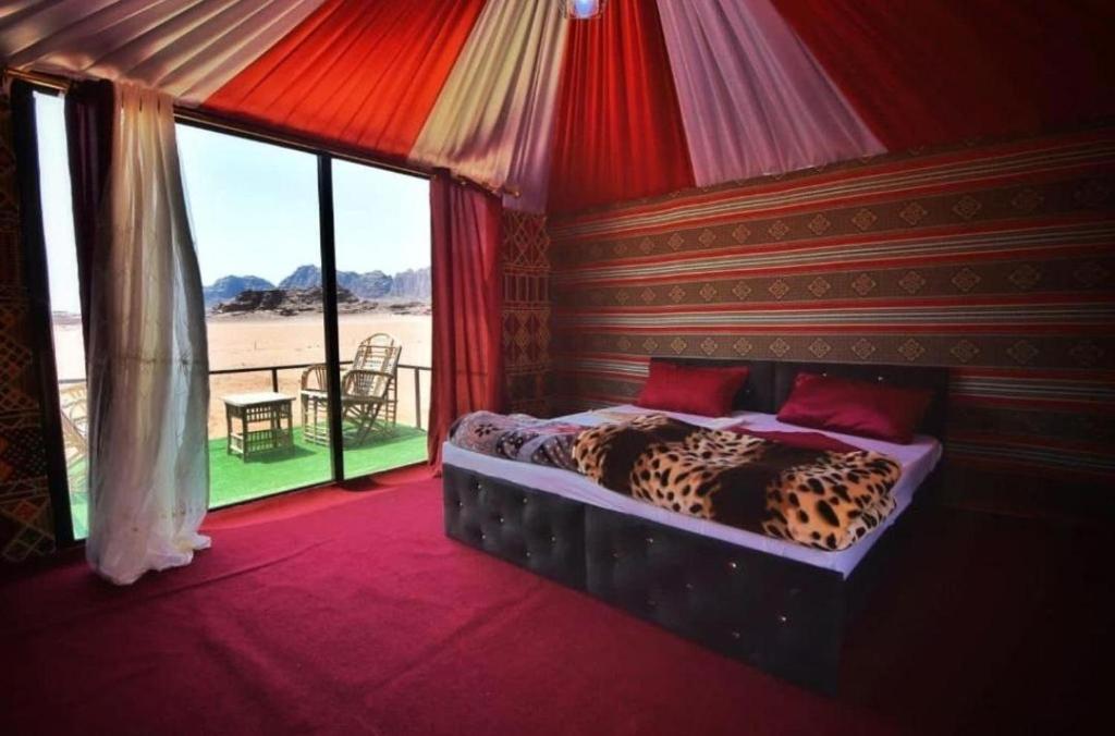 um quarto com uma cama de leopardo numa tenda em Russell desert camp em Disah