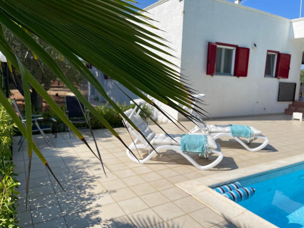 a pool with two lounge chairs next to a house at Da Ksenia in Ceglie Messapica