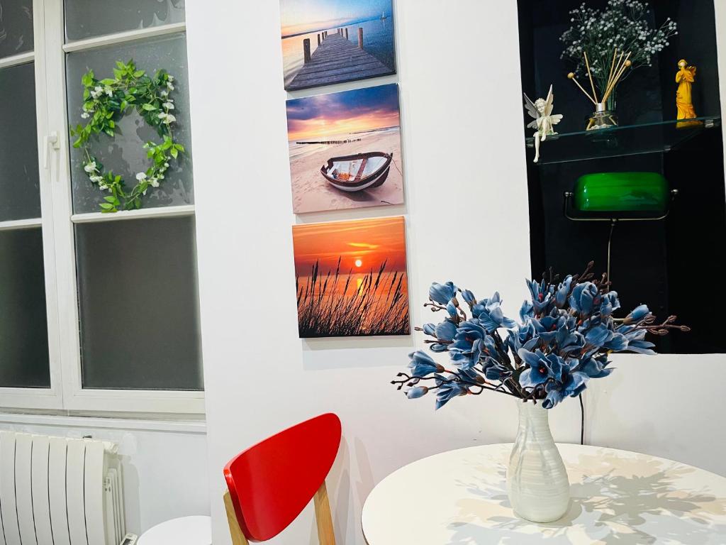 a table with a vase with blue flowers on it at Dream Dwell Paris-Chic flat in the heart of Marais near Pompidou Centre in Paris