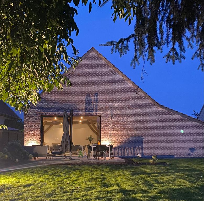 a brick building with a table and chairs in a yard at Hoeve De Kleinheide in Dessel