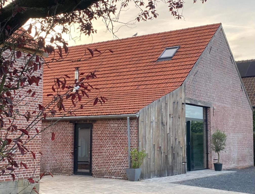 a brick building with an orange roof at Hoeve De Kleinheide in Dessel