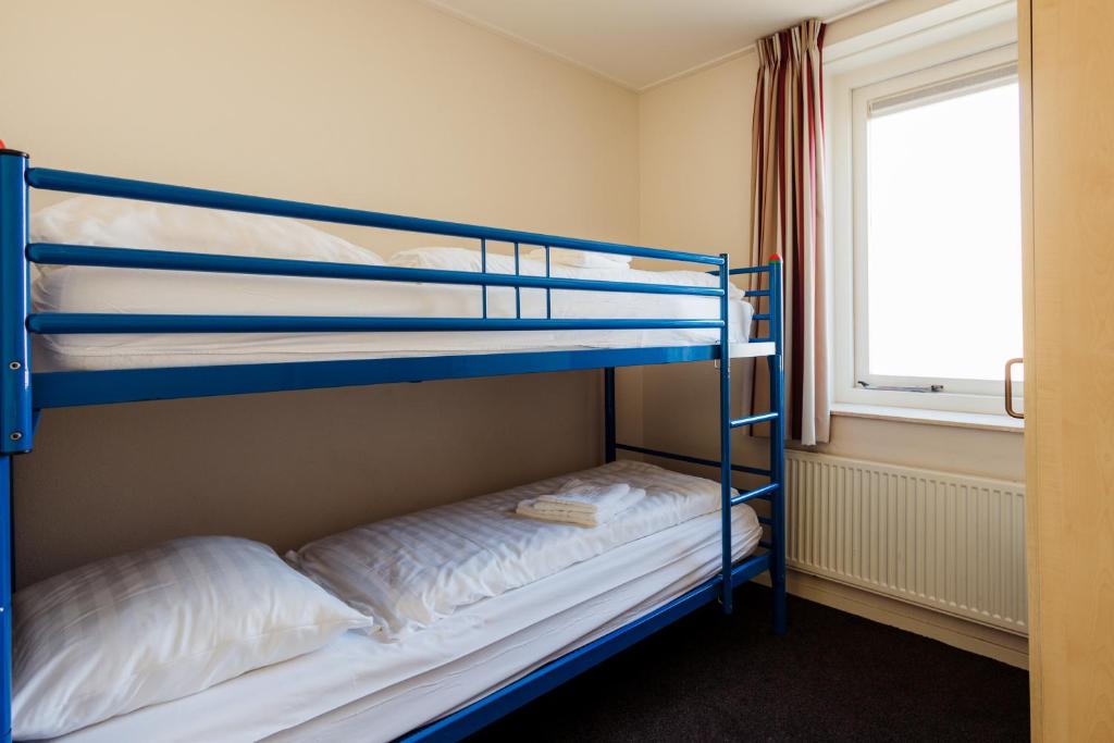 two bunk beds in a room with a window at Appartementen Hotel Meyer in Bergen aan Zee