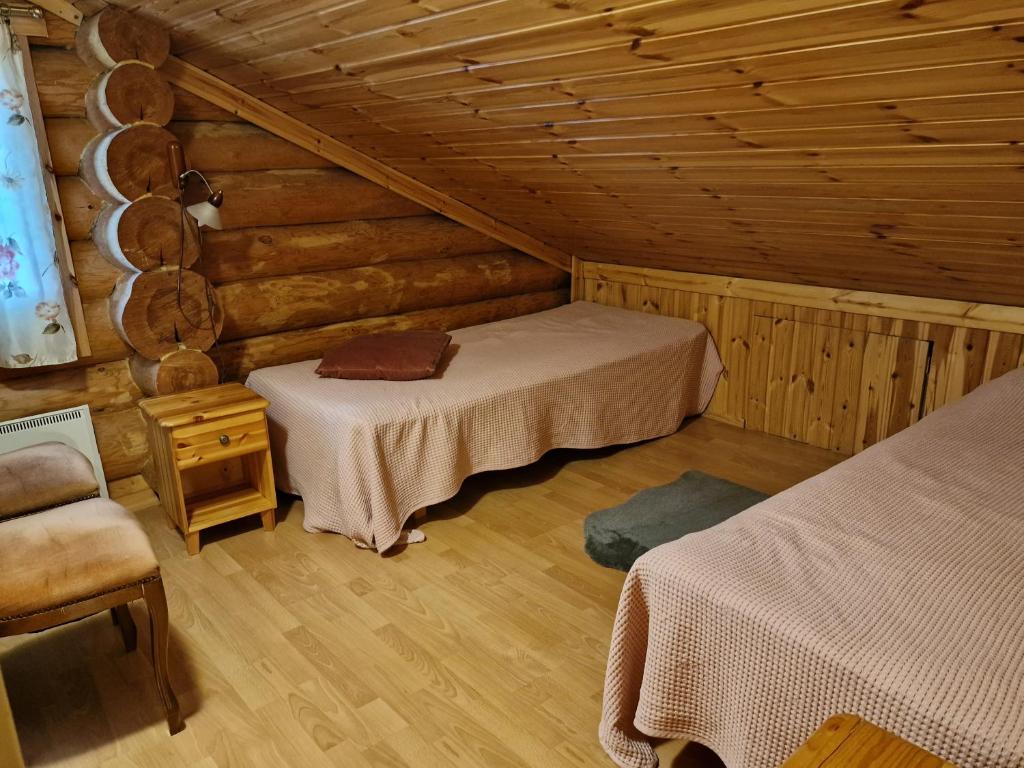 VehviläにあるVacation Home Kuhmanneのログキャビン内のベッドルーム1室(ベッド2台付)