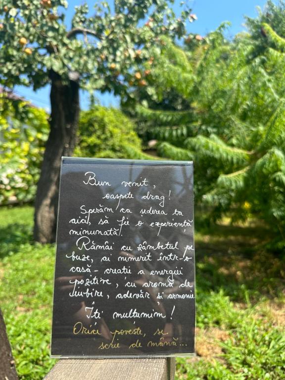 a chalkboard sign with writing on it in a park at La Mosie in Corbu