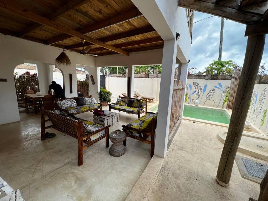 a living room with couches and a swimming pool at Villa64 - Afrikanische Villa mit Pool in Nungwi