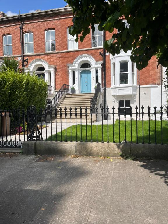 a fence in front of a house with a blue door at Kenilworth Square North in Dublin