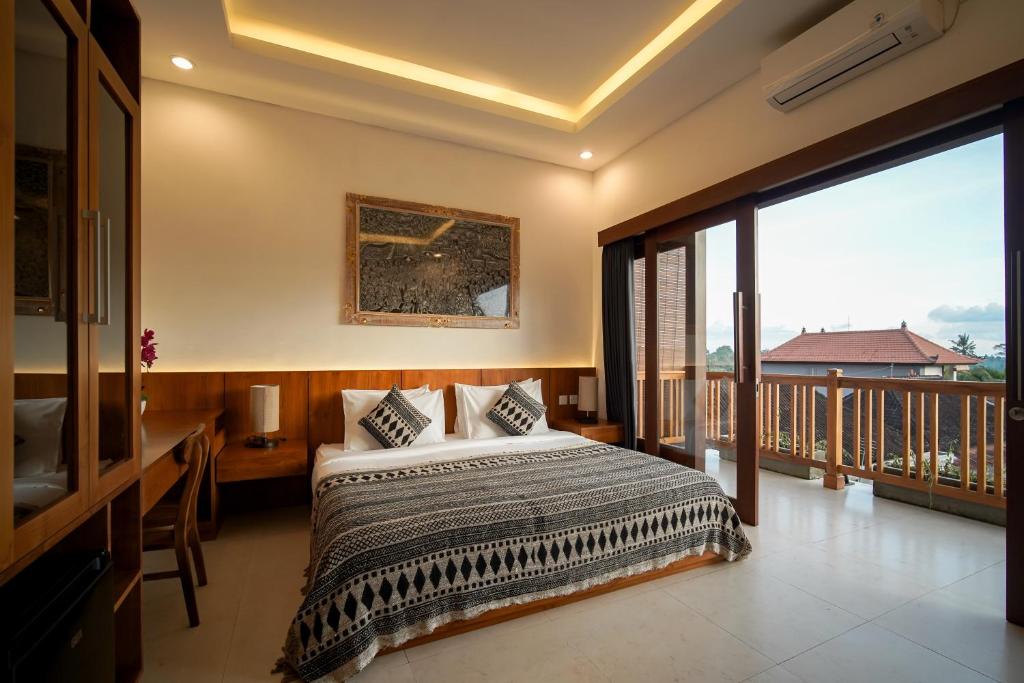 a bedroom with a bed and a balcony at Wakasuta House in Ubud