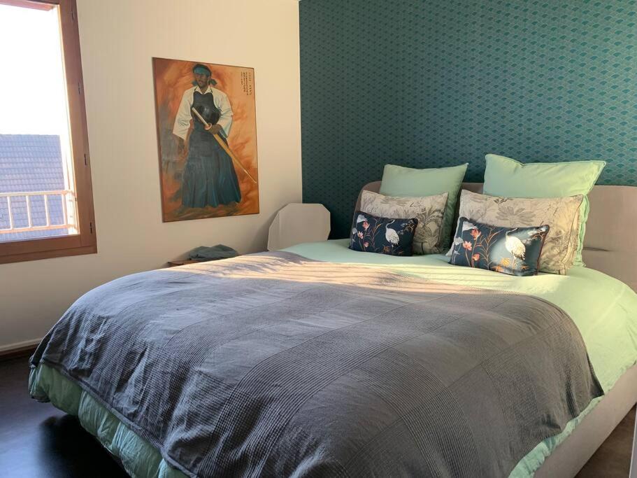 1 dormitorio con 1 cama grande y una pintura en la pared en Appartement terrasses proche Orly & Paris, en Chevilly-Larue