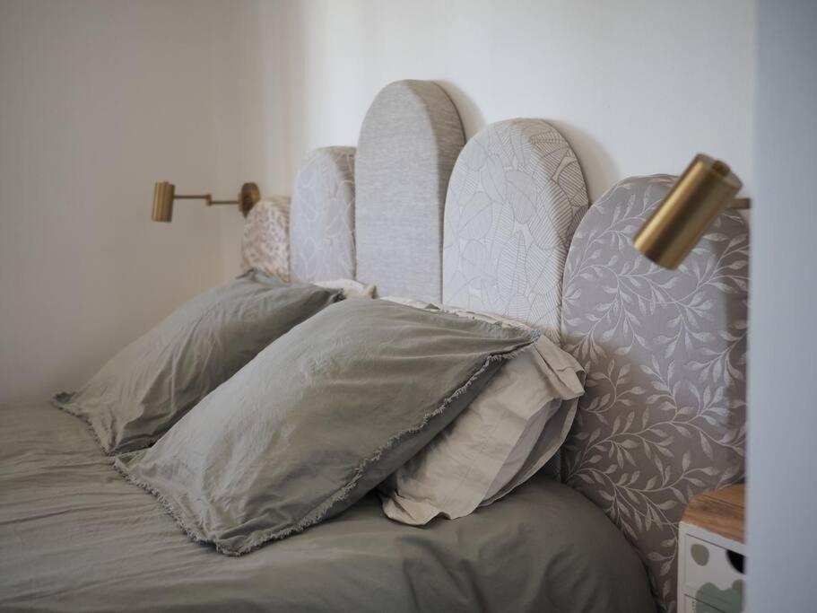 een bed met kussens in een slaapkamer bij L Arancera - Sant Anghjulu - Appartement cosy in Penta-di-Casinca