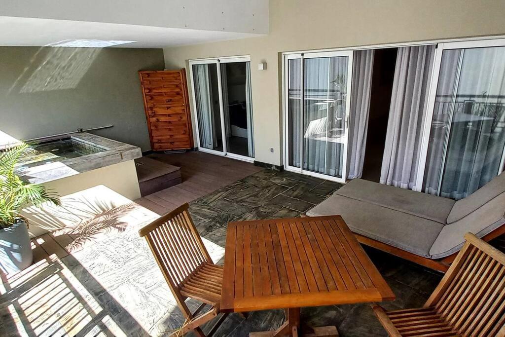 sala de estar con sofá, mesa y sillas en Beachfront 2 Bedroom Apartment en Bain Boeuf