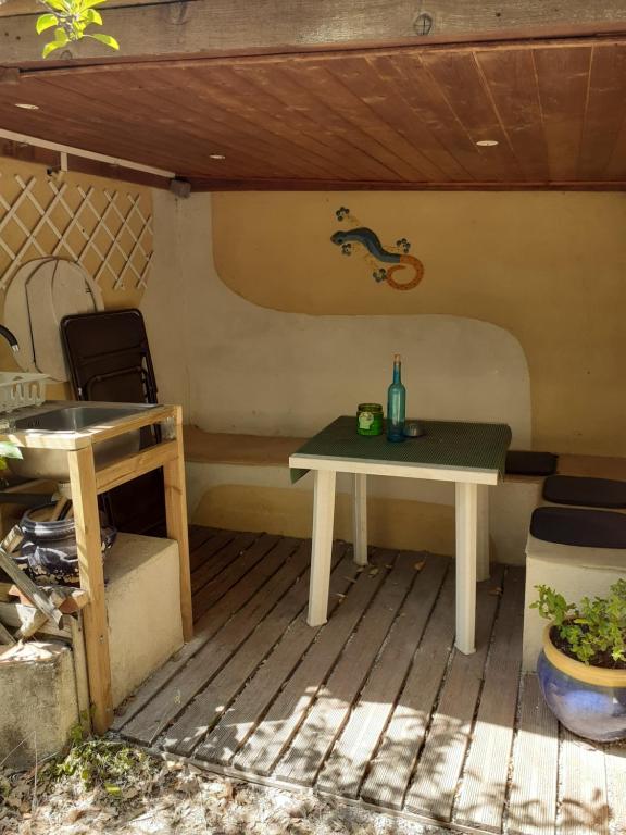 Gonfaron的住宿－petit studio a la campagne , prévenir entre 3 et 4 heures avant l'arrivée，坐在房子后面的桌子