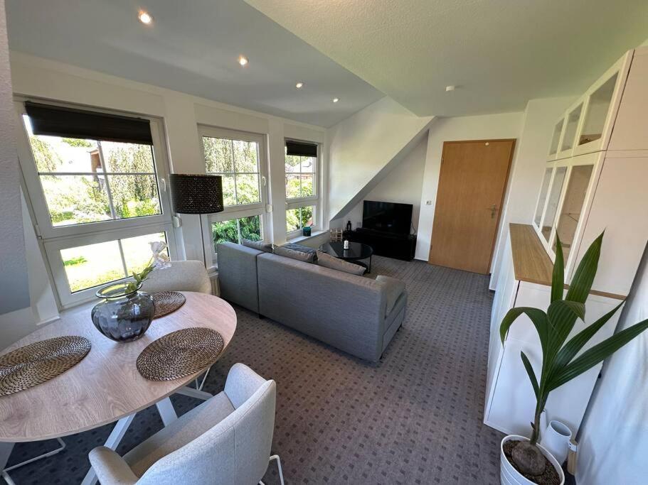 a living room with two tables and a couch at Idyllische Ferienwohnung Sillenstede in Schortens