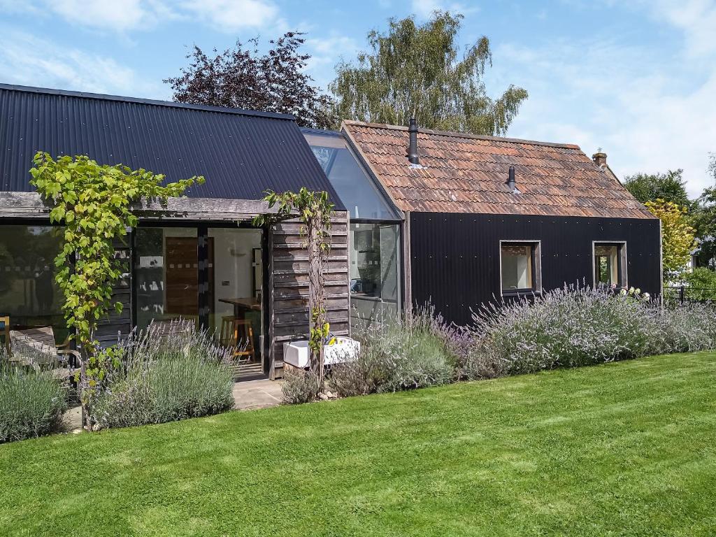 una casa nera con un giardino di fronte di Wrens Nest a Chippenham