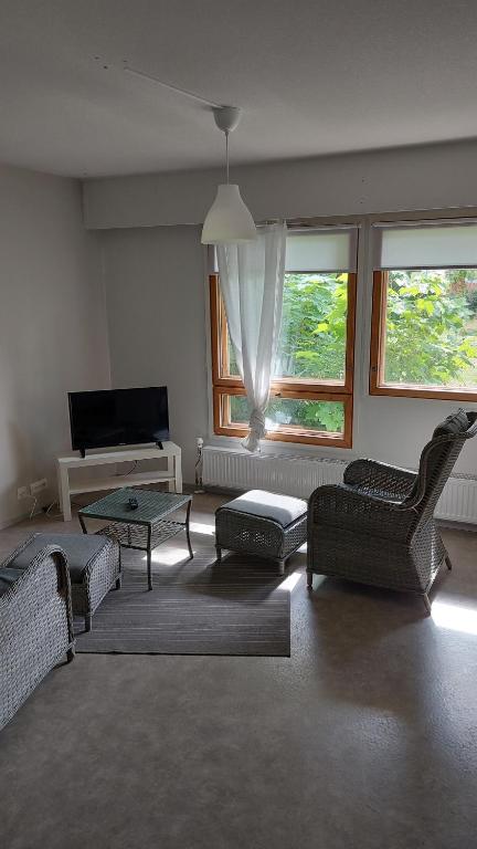 a living room with couches and a tv and windows at Apartment in Kauhajoki, Yrjöntie 10 in Kauhajoki