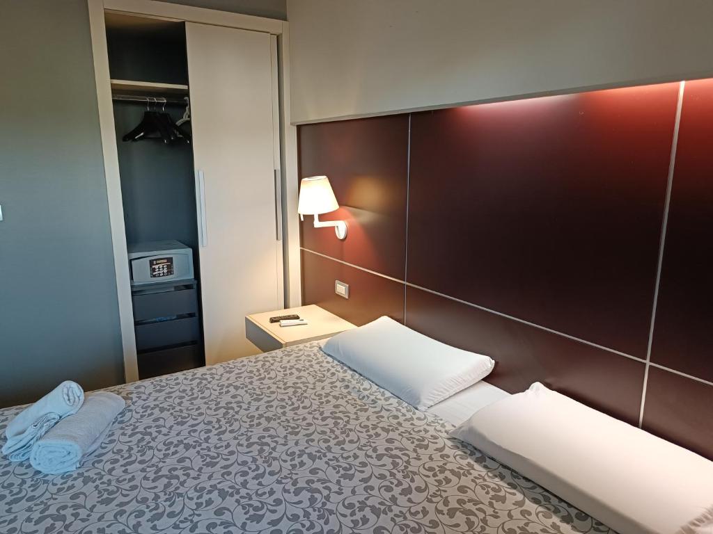 um quarto com uma cama com duas almofadas brancas em Suite Apartment Domus Cosenza em Cosenza