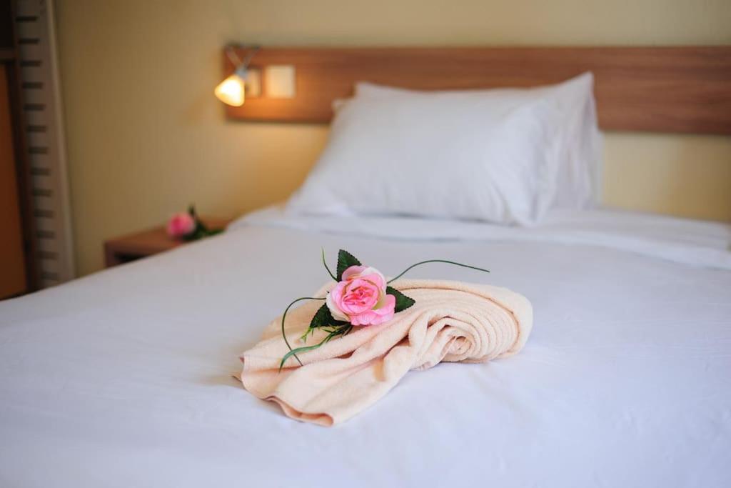 a towel with a rose on top of a bed at Élégant studio proche Paris, disponible 24&#47;7. in Pantin