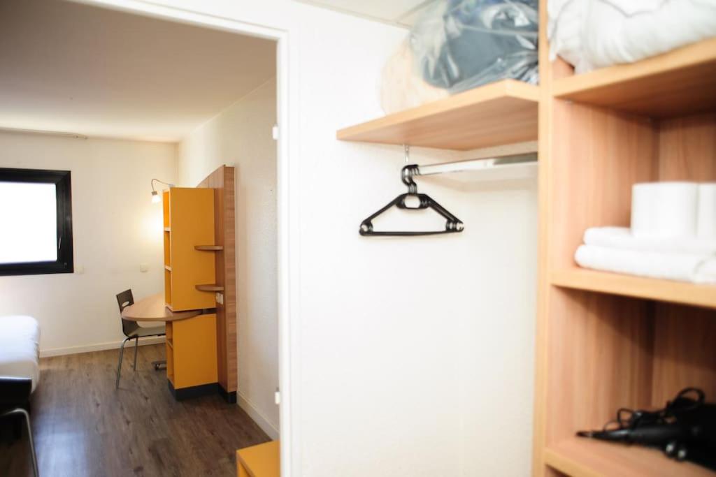 a room with a closet with a mirror and a desk at Élégant studio proche Paris, disponible 24&#47;7. in Pantin