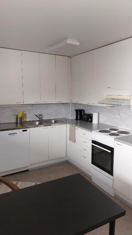 a kitchen with white cabinets and a stove top oven at Apartment in Kauhajoki, Yrjöntie 5 in Kauhajoki