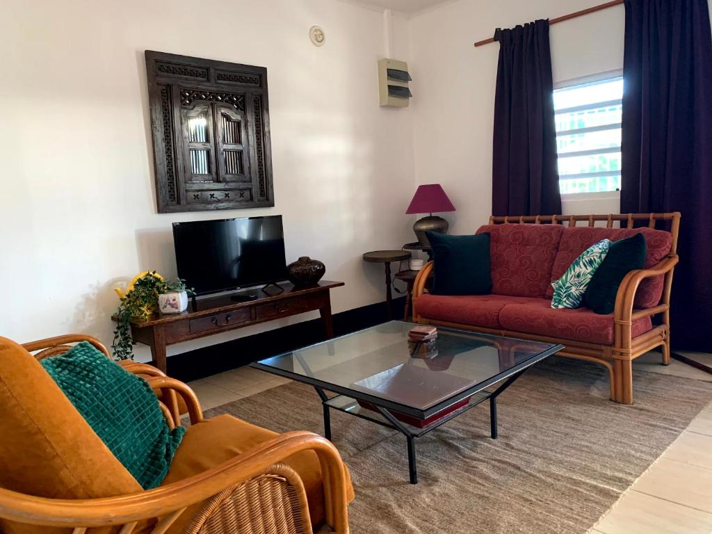 sala de estar con sofá y mesa de centro en Klein-kronenburg Bakkershuisje, en Paramaribo