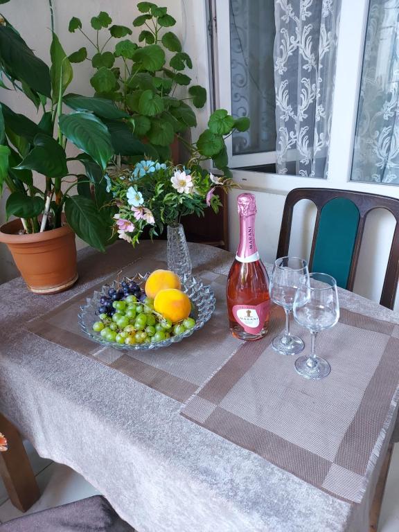a table with a plate of fruit and wine glasses at Luka in Tbilisi City