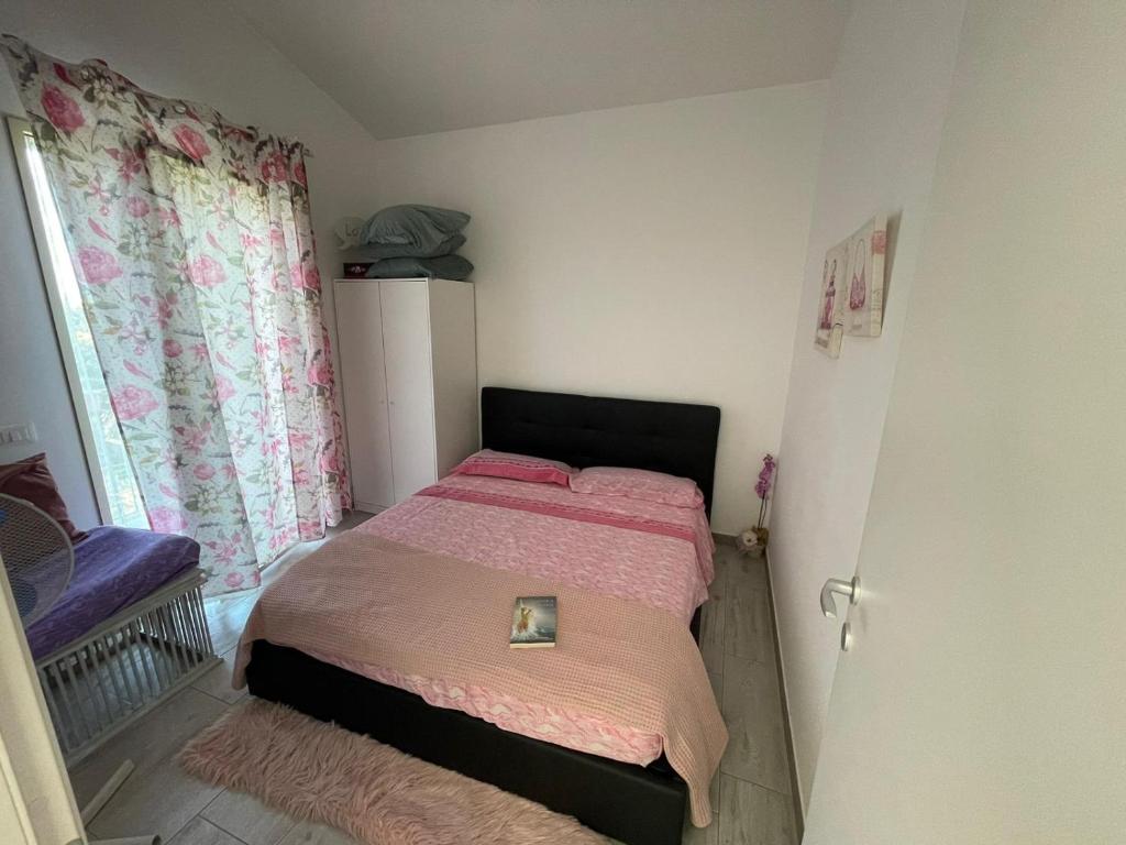 um pequeno quarto com uma cama e uma janela em Camera con bagno privato em Ragalna