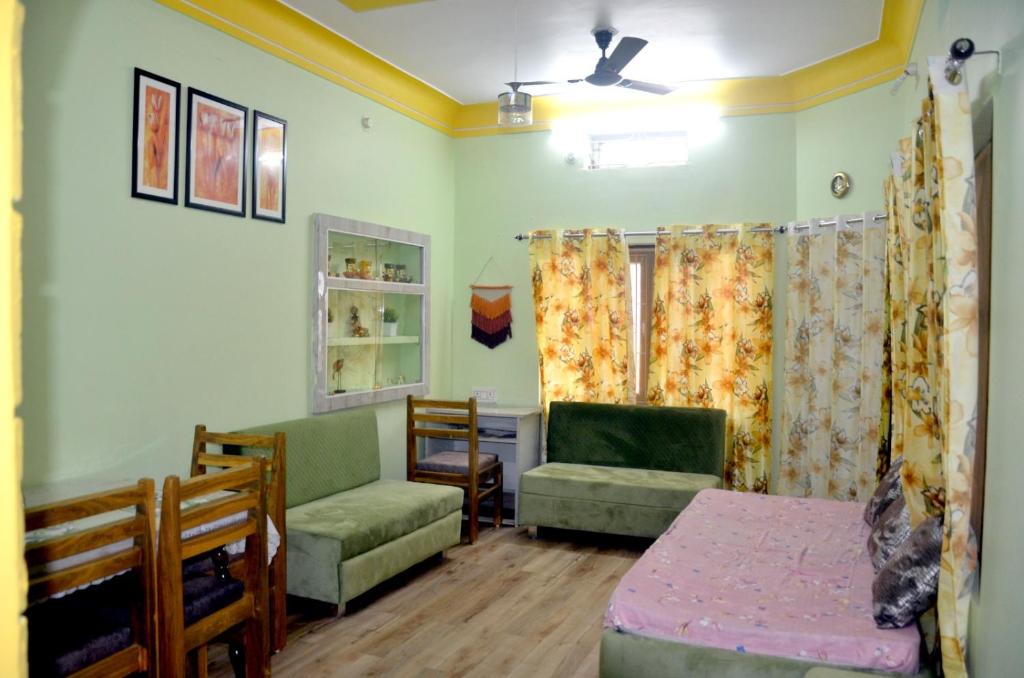 een woonkamer met een bank, stoelen en een tafel bij Pinakin Homestay in Ujjain