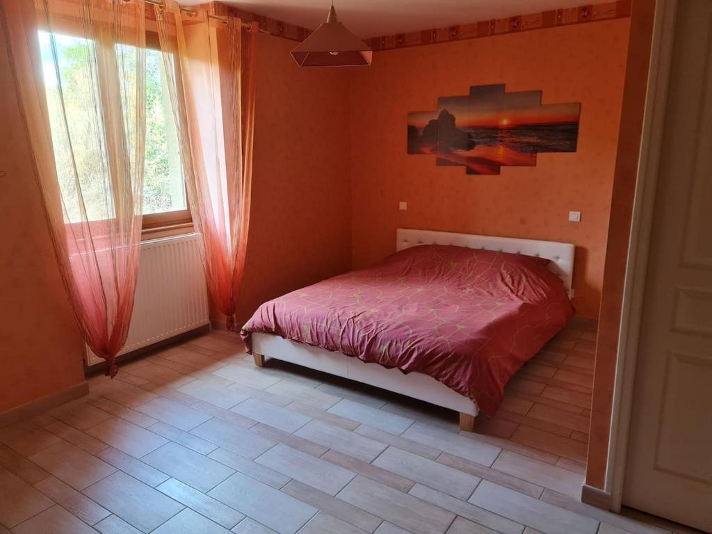 a bedroom with a bed in a room with orange walls at Au Pilandre in Arinthod